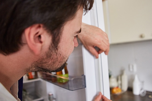 How do you unclog the defrost drain on a Whirlpool refrigerator